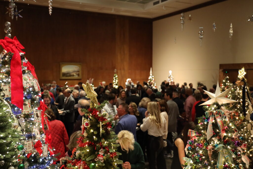 A crowd of people among decorated trees