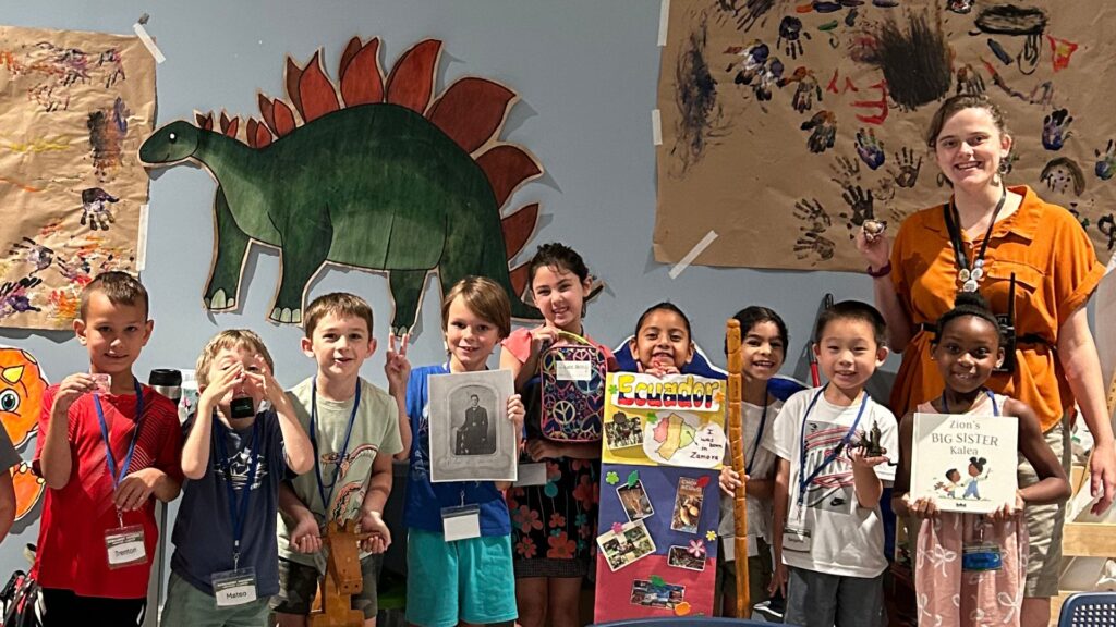 A room full of smiling kids inside a room.