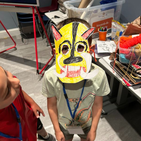 A young child wearing a handmade mask.